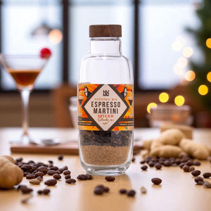 Bottle of Espresso Martini mix with coffee beans on a table with blurred background
