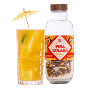 Pina Colada bottle with a glass of yellow cocktail on a white background
