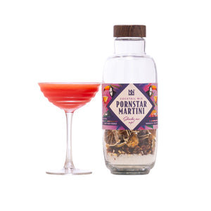 Bottle of 'Pornstar Martini' cocktail mix with a labeled glass of red cocktail on a white background
