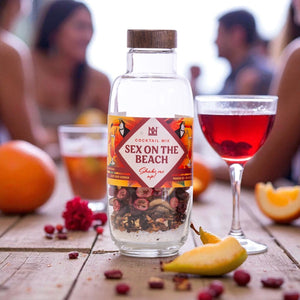 Bottle of 'Sex on the Beach' cocktail mix with a blurred social setting in the background