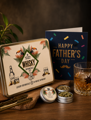 Glass of Whisky, alongside Natural & Noble DIY Whisky Kit, Open Tins of Botanicals and Fathers day Card