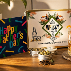 Glass of Whisky, alongside Natural & Noble DIY Whisky Kit, Open Tins of Botanicals and Fathers day Card